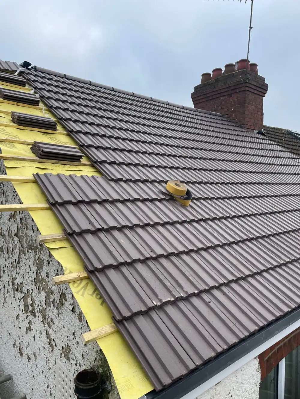 New brown tiles going on over yellow membrane