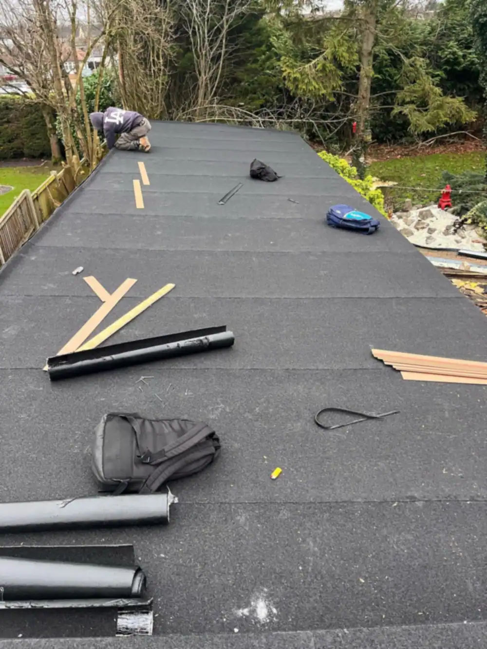 Felt flat roof mid laying with tools and rolls