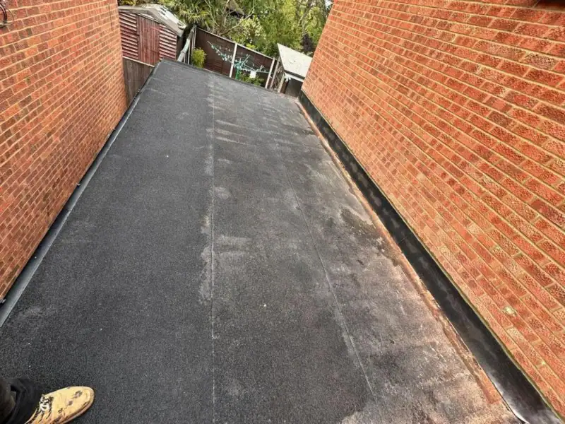 Finished felt flat roof between two walls with a neat dressed edge