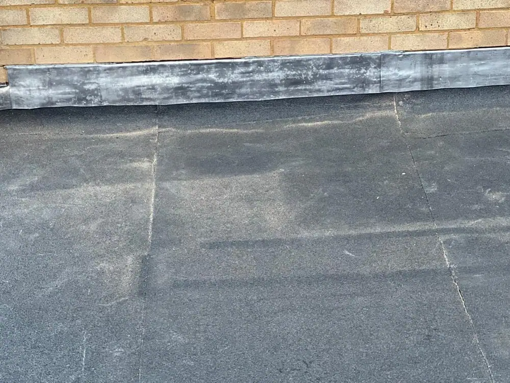Finished felt flat roof with lead dressed at the wall