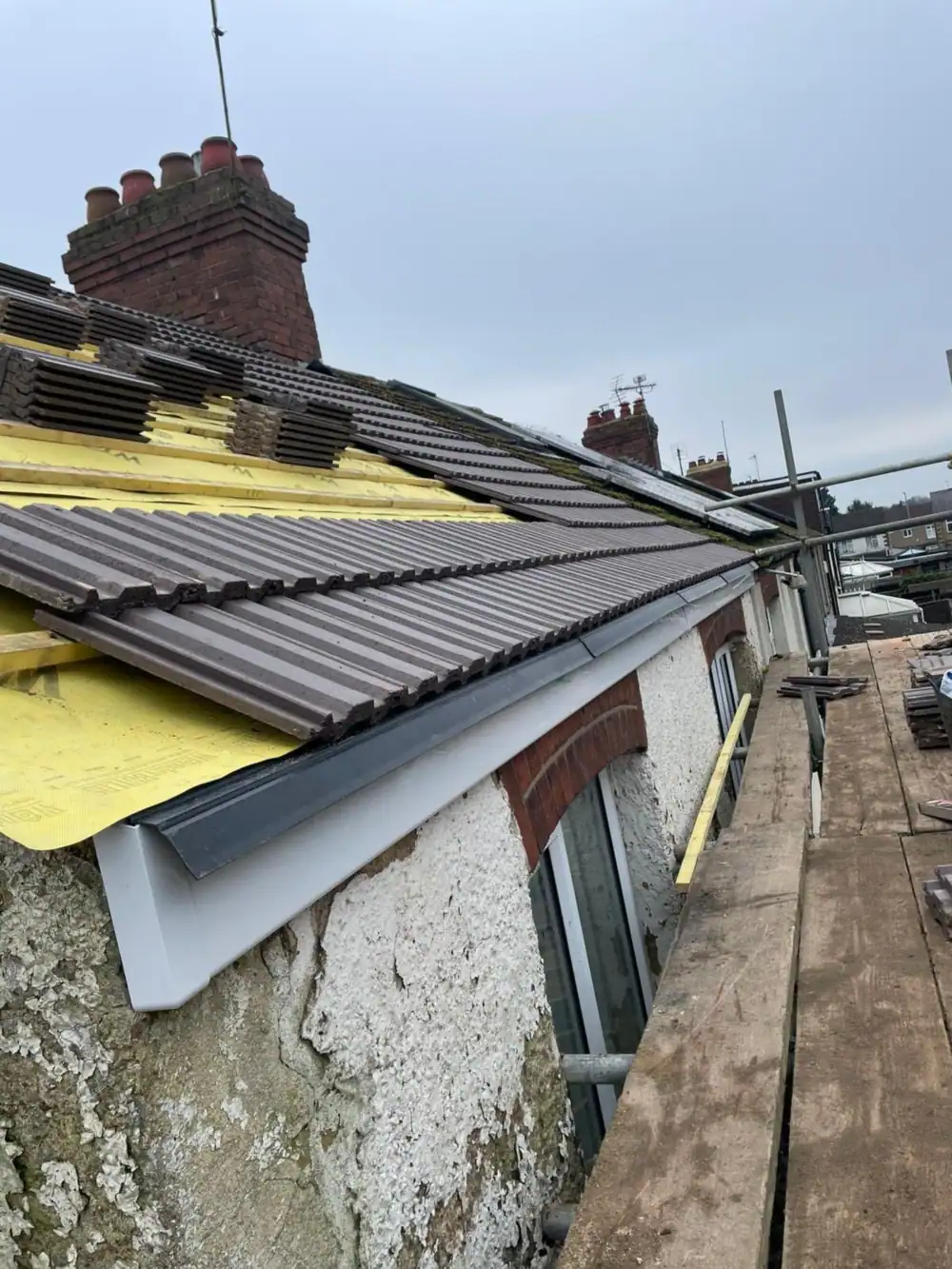 Lower roof slope tiled with membrane at the top