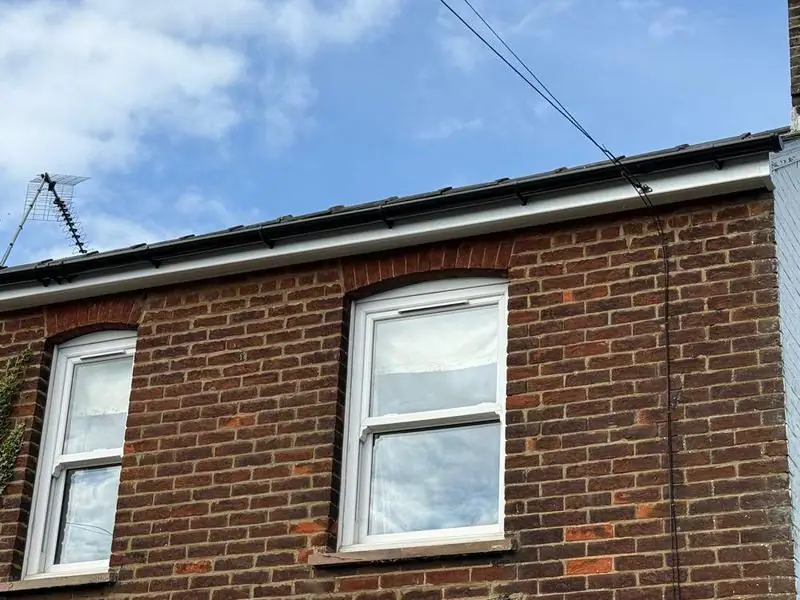 New black fascia and gutter on a brick house