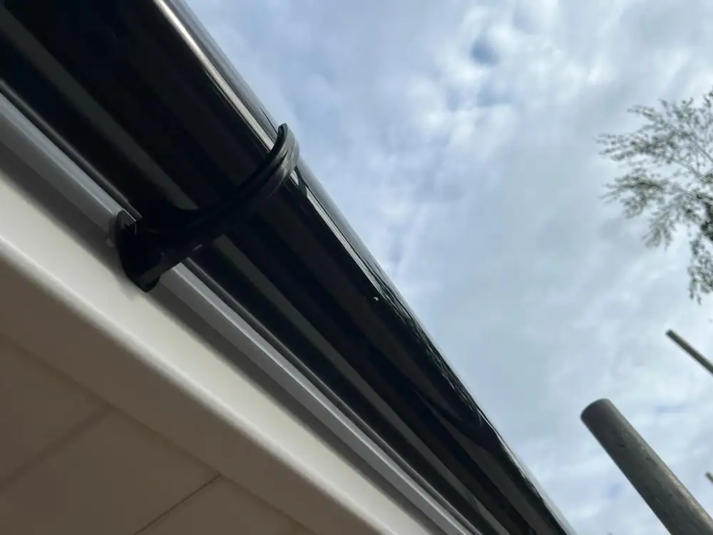 Close-up of new black half-round gutter on a white uPVC fascia