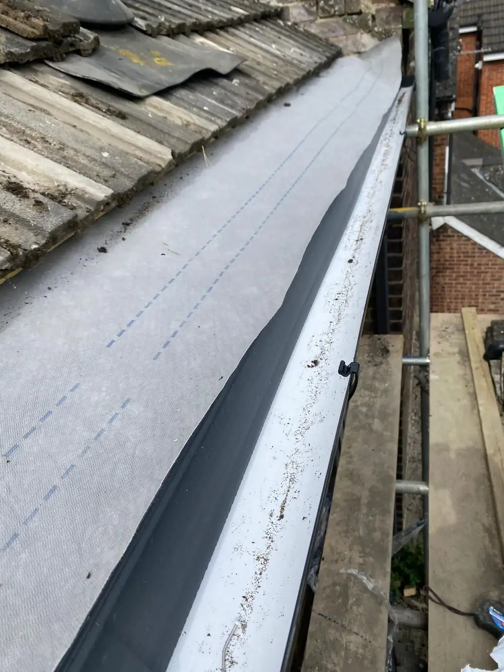 New eaves and gutter line seen from the scaffold during gutter replacement