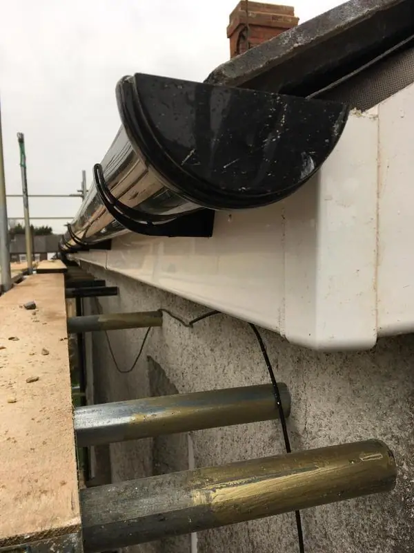 New white fascia and black gutter from the scaffold