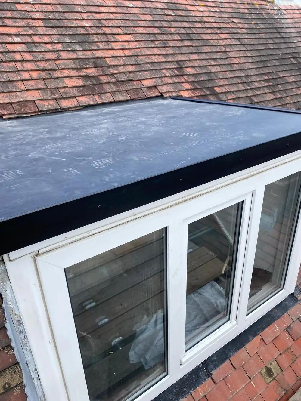 New flat roof on a dormer above a white window