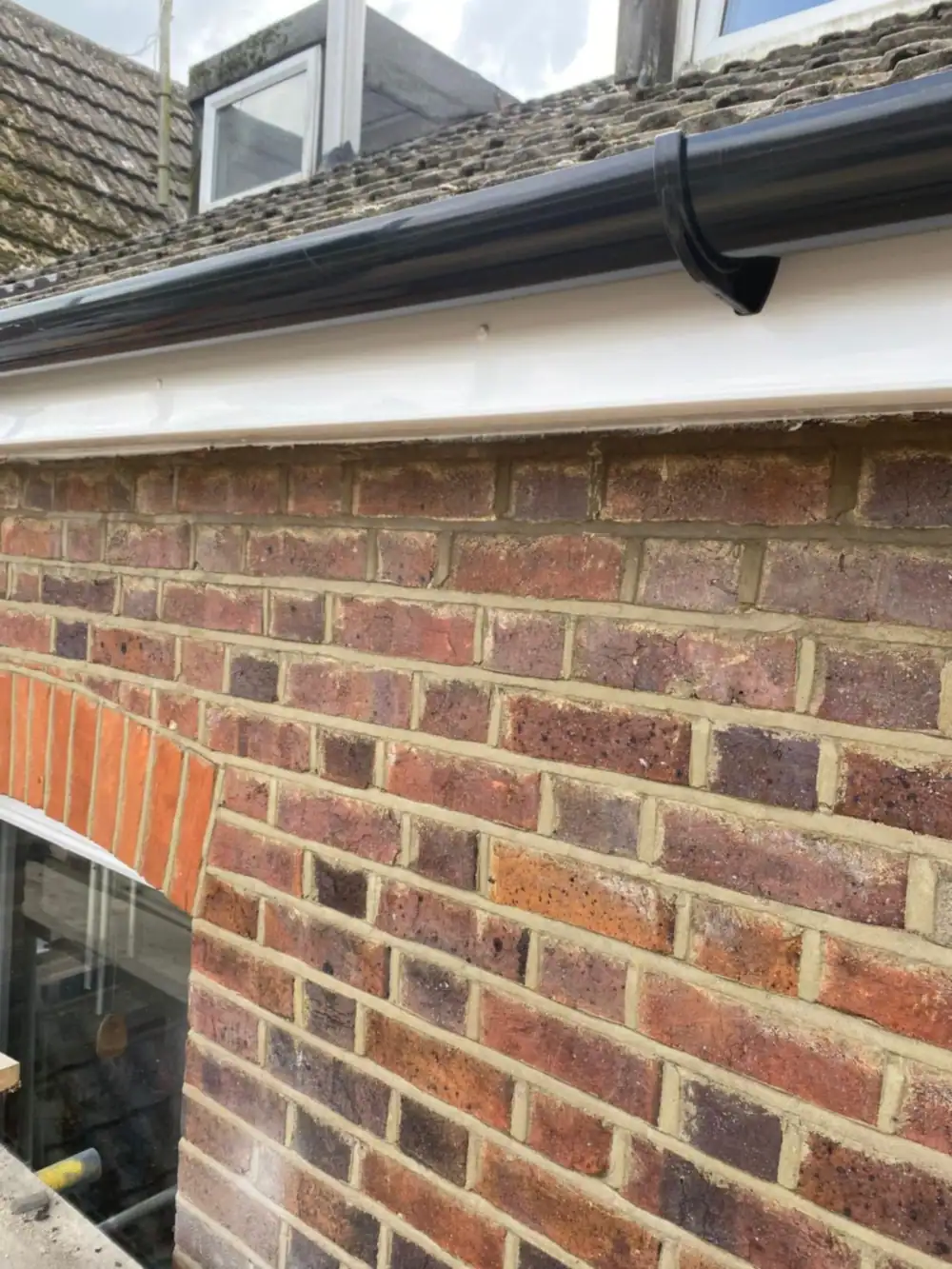 New black gutter and white fascia over brickwork, the first place we check for damp