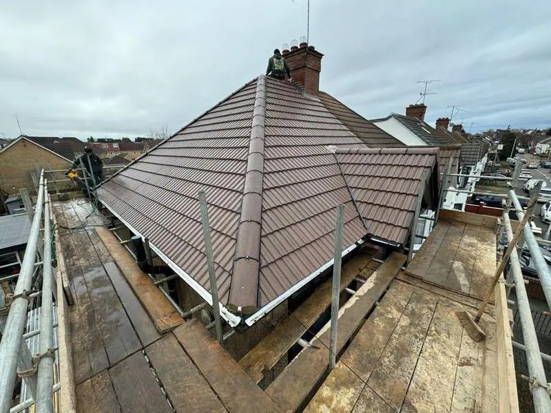 Roofers in Bedfordshire and Hertfordshire: a new hipped tile roof with scaffold around it
