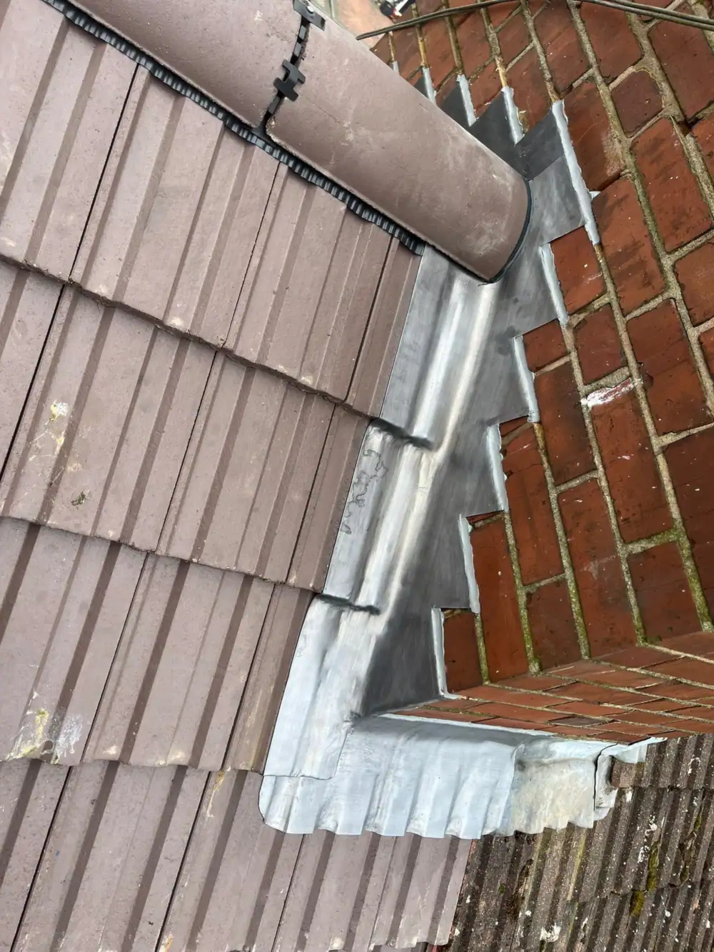 New tiles with lead abutment flashing and ridge