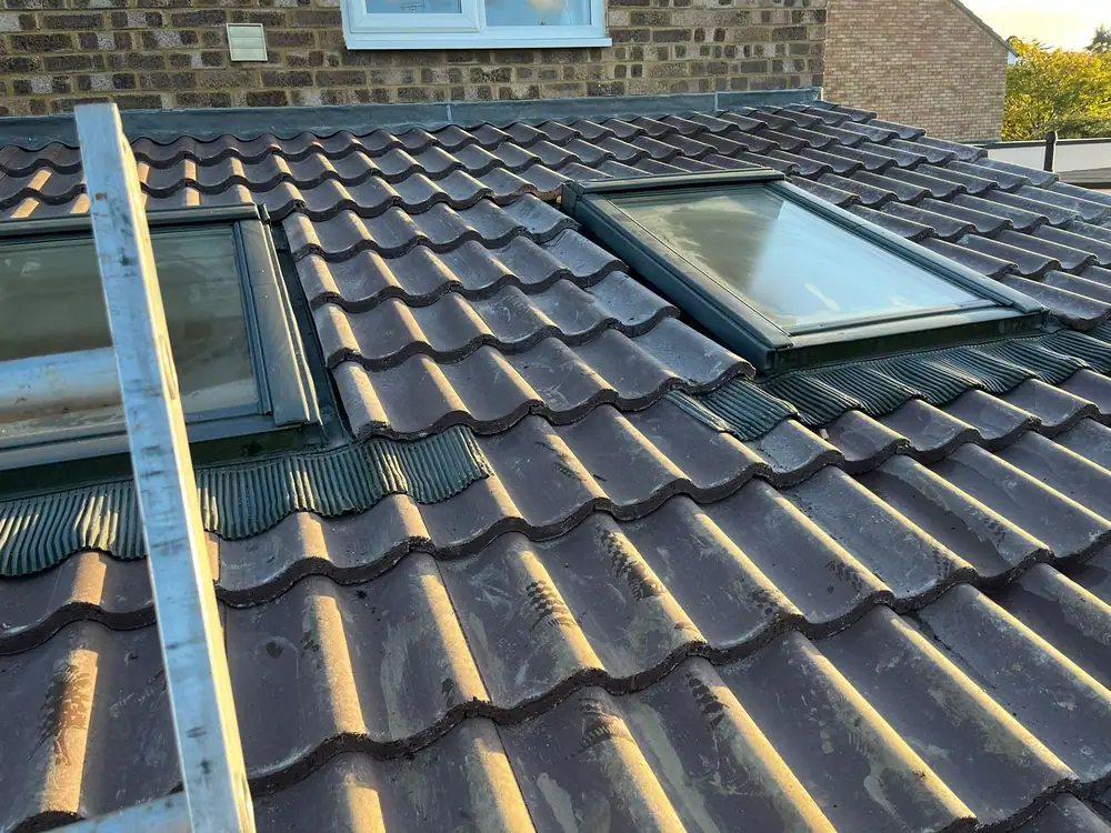 Roofers in Luton: new interlocking tiles fitted around two roof windows