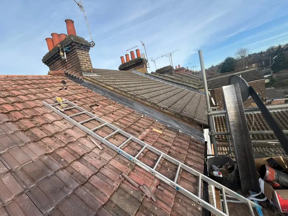 Old red tile terrace roof with a roof ladder before work
