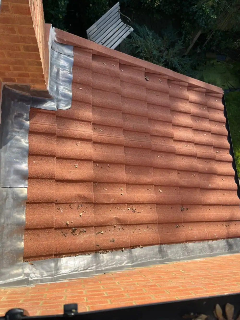 Lead roofing detail: new red interlocking tiles with lead flashing at the side abutment
