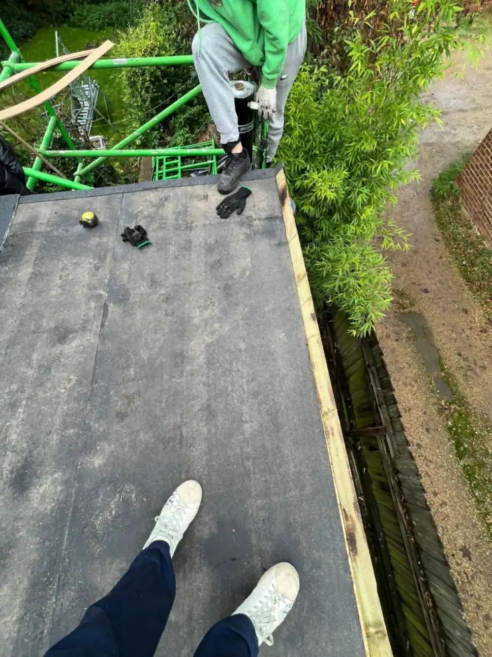 Rubber flat roof being laid, worker standing on the deck