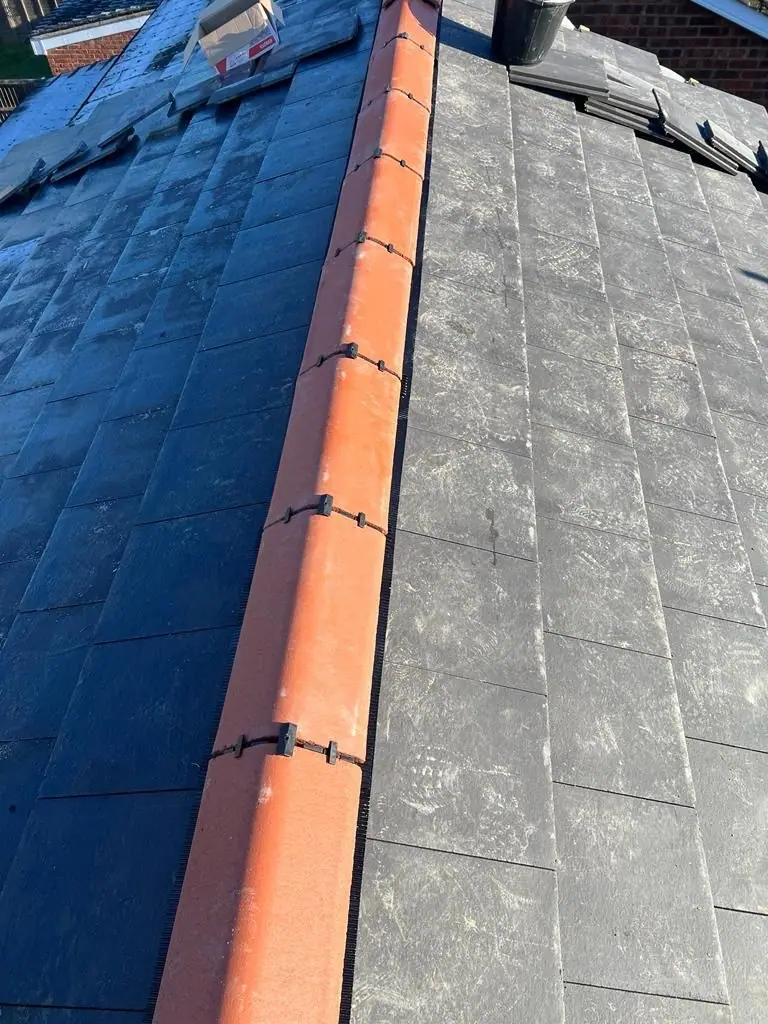 Ridge line of the new slate-effect roof with terracotta ridge tiles
