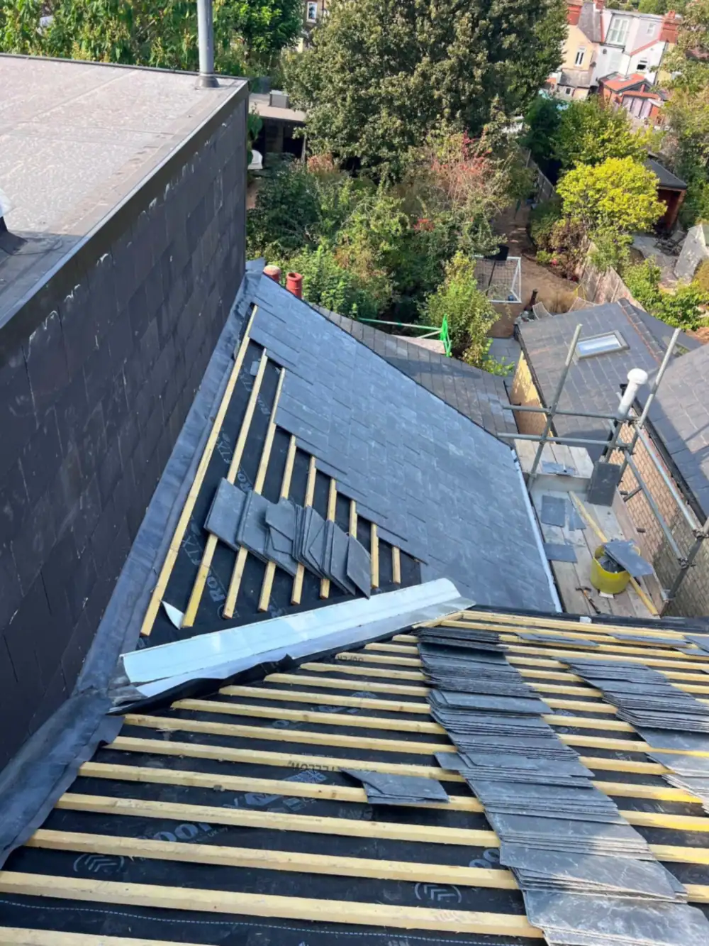 Slates being fixed around a dormer with lead and battens showing during slate roofing