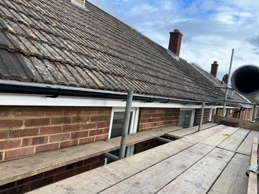 Long concrete tile roof seen from the scaffold boards before work starts