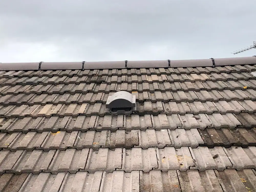 Tiled roof with a new vent tile fitted during roof tile replacement